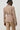 Person wearing a beige suit against a white background