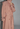 Pink trench coat with black accents on a plain background